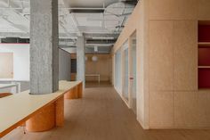 an empty office space with wooden floors and white counter tops on either side of the room