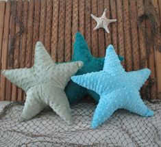 three blue and white starfishs sitting next to each other on a netted surface