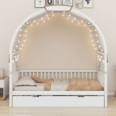 a white bed with lights on the headboard and foot board in front of it