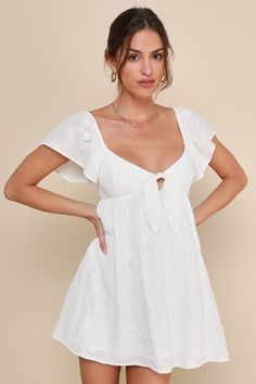 Make everyone feel like they're on cloud nine by just looking at you in the Lulus Heavenly Cutie White Embroidered Tie-Back Mini Dress! Lightweight cotton-blend fabric, with pierced eyelet embroidery throughout, shapes a V-neckline that secures with a cute tie detail atop a keyhole-style cutout. Fluttery short sleeves (with elastic at the shoulders) frame the seamed bodice and the fitted empire waist that sits atop an A-line mini skirt. Turn around to reveal an open-back design with sash ties. E Summer Cotton Mini Dress With Broderie Anglaise, Chic Floral Embroidery Cotton Mini Dress, Chic Cotton Mini Dress With Floral Embroidery, Chic Cotton Mini Dress With Broderie Anglaise, Spring Cotton Mini Dress With Broderie Anglaise, Floral Embroidered Cotton Mini Dress For Brunch, Cotton Mini Dress With Floral Embroidery For Brunch, White Wedding Guest Dresses, Knot Tie Dress