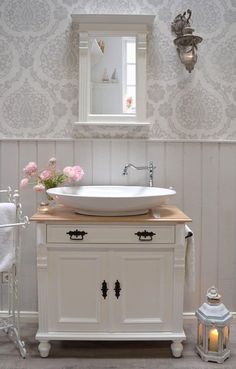 a white sink sitting under a mirror in a bathroom