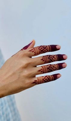 a woman's hand with henna tattoos on it