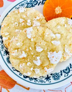 two cookies and an orange on a plate