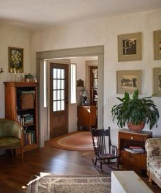 a living room filled with furniture and pictures on the wall above it's doorway