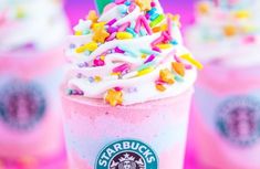 three starbucks drinks with sprinkles and confetti on the top one is pink