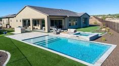 a backyard with a swimming pool, patio and fenced in area that has grass on the ground