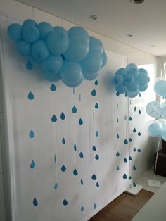 blue balloons and raindrops are hanging from the wall