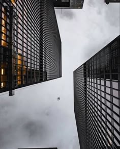 an airplane flying through the sky between two buildings