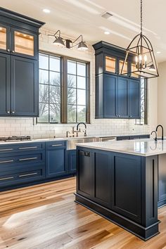 a large kitchen with blue cabinets and wooden floors