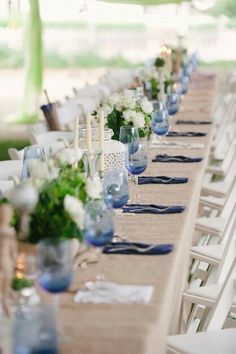 a long table with blue and white place settings