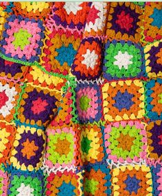 a multicolored crocheted blanket with squares on the bottom and one square in the middle