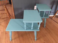 three blue tables sitting on top of a hard wood floor next to a wooden chair