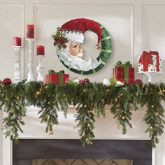 a mantel decorated with greenery and christmas decorations