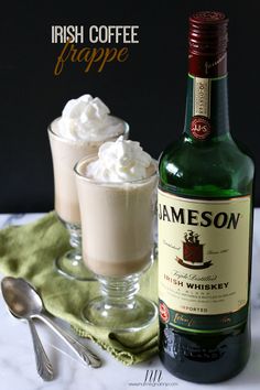 irish coffee and whipped cream in glasses on a table with spoons next to it