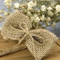 a bunch of white flowers sitting on top of a wooden table next to burlock