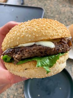 a close up of a person holding a hamburger