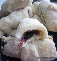 several pastries are stacked on top of each other with jam in the middle and powdered sugar around them