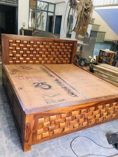 a bed frame made out of wood with an intricate design on the headboard and foot board