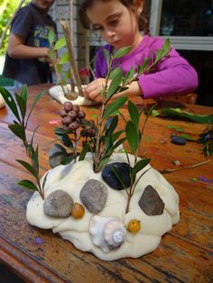 two children are playing with rocks and plants