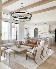 a living room filled with lots of furniture and a chandelier hanging from the ceiling