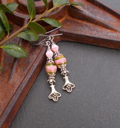 "Pretty in pink! Unique glass and flower drops, these botanical earrings are slightly rustic and perfect for everyday wear. The flower charm is silver plated and antiqued. The pink glass beads have so much visual interest - the larger beads are oval pillow-shaped, pastel pink with veins of dark green. The smaller milky pink beads are bicone shaped. I've included some beautiful and intricate silver plated beads and finished the earrings with long silver plated ear wires. Earring Length: a little Pink Sterling Silver Dangle Flower Earrings, Pink Nickel-free Bohemian Flower Earrings, Bohemian Pink Nickel-free Flower Earrings, Vintage Pink Nickel-free Flower Earrings, Pink Sterling Silver Flower Earrings Nickel Free, Pink Bohemian Sterling Silver Earrings, Bohemian Pink Sterling Silver Earrings, Trendy Jewelry Ideas, Milky Pink