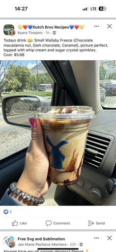 a woman holding up a cup of coffee in her hand while sitting in a car