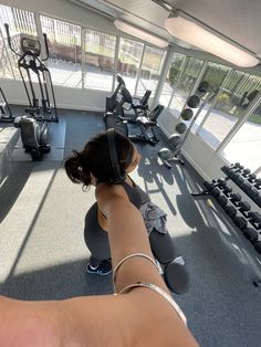 a woman is doing exercises in the gym with headphones on her ears and arm