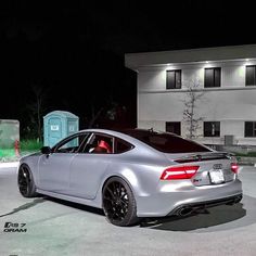 a silver car parked in front of a building at night