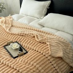 a bed with white pillows and a blanket on it's headboard is shown