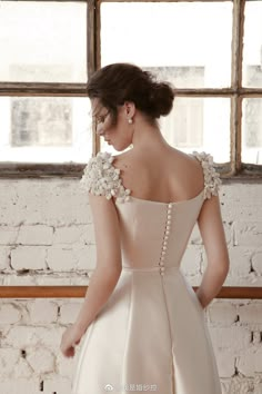 the back of a woman's wedding dress with flowers on her shoulder and shoulders