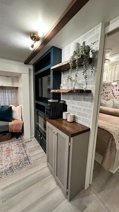 a living room filled with furniture next to a bed and a kitchen counter top oven