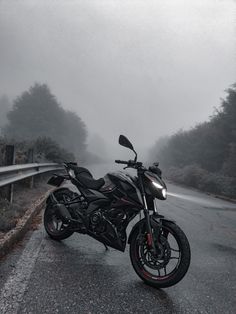 a motorcycle is parked on the side of the road in the middle of the fog