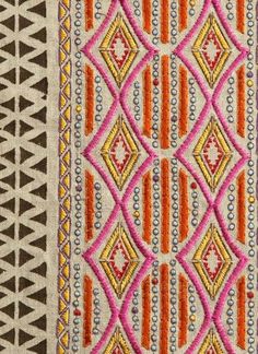 an orange, pink and brown rug with geometric designs on the bottom half of it