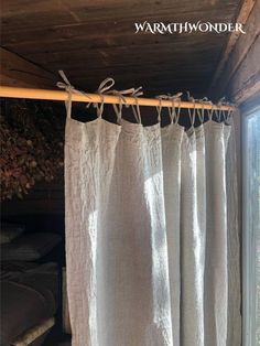 the curtain is hanging in front of an open window with curtains pulled back and tied together