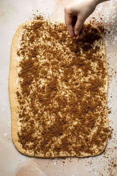 someone is kneading some food on top of a doughnut sheet with cinnamon sprinkles