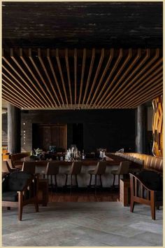 Wooden-beamed ceiling above an elegant dining area with a long table, armchairs, and a bar in the background. Cabo Style, Cabo San Lucas Hotels, Cabo Wabo, Thompson Hotel, Hotel San Jose, Prosecco Bar, Resort Architecture, Cabo Wedding