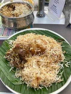 a plate with rice and meat on it sitting on a table next to other plates