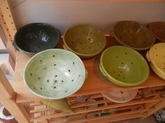 several bowls are lined up on a shelf