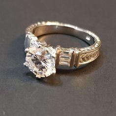 an engagement ring with two baguets on the side and a diamond in the middle