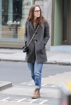 a woman walking down the street with her hand in her pocket