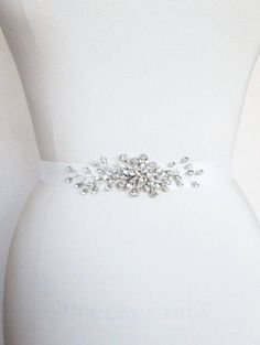 "This petite belt features elegant Swarovski crystal design appliquéd on a grosgrain ribbon sash. The crystal part of the sash measures about 5\" long and 1 1/2\" wide. The ribbon measures 1\" wide and 150\" long. Available is gold or silver finish and a variety of ribbon options. - For the photo of the grossgrain ribbon color options, please take a look here: https://www.etsy.com/listing/231071205/grosgrain-ribbon-swatches-ribbon-color?ref=shop_home_active_18 - For the photo of the satin ribbon Wedding Belts With Sashes, Silver Bridal Accessories For Party, Silver Bridal Accessories With Sashes For Party, Silver Sashes For Bridal Party Accessories, Silver Bridal Belt With Sashes For Formal Occasion, Silver Embroidered Belt Sash For Party, Elegant Adjustable Embroidered Belt, Silver Embroidered Sash For Party, Elegant Embellished Sashes