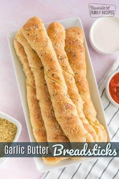 breadsticks on a plate with dipping sauce and seasoning