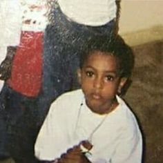 an old photo of a young boy sitting in front of a fire hydrant