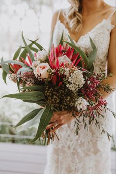 a woman holding a bouquet of flowers in her hands