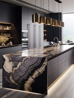 a large kitchen with marble counter tops and black cabinets, along with gold pendant lights hanging from the ceiling