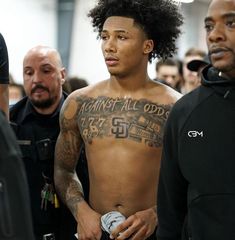 a man with tattoos on his chest is surrounded by police