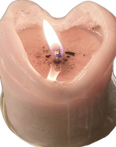 a heart shaped candle with a lit candle inside