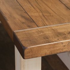 a close up of a wooden table with white legs and wood grain on the top