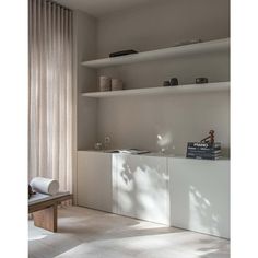 a living room filled with furniture next to a wall mounted book shelf on top of a hard wood floor