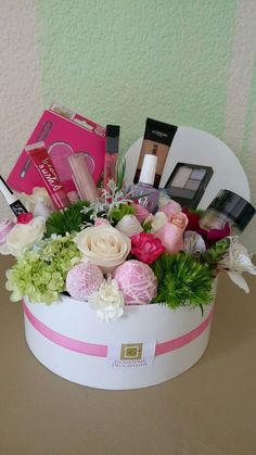 a white box filled with lots of different types of cosmetics and flowers on top of a table